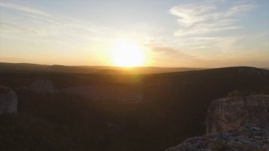 Gün batımı ve dağlar yatay olarak. Vurdu. Dramatik gökyüzü günbatımı Kanyon görünümünü. Renkli taşlar ve güneş ışınları. Renkli gündoğumu resim orman ve yukarıda da görüleceği kayalardan meadows.