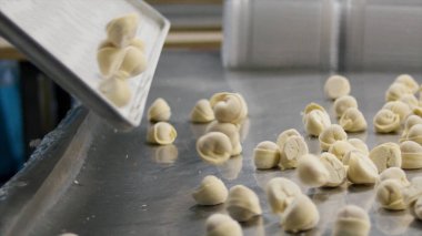 Et köfte bir kap içinde bulunan ve kaldırılmakta olan daha sonra bir tepsiye bırakılır. Hazır düşen köfte etli