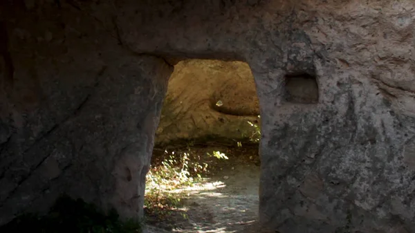 Древняя пещера с дверью. Выстрел. Интерьер с очагом старинной комнаты в пещере. Из старых пещер, каменные стены. Из старых пещер, каменные стены . — стоковое фото
