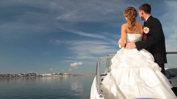Только что поженились на яхте. Сцена. Счастливые жених и невеста в день их свадьбы. Свадебная пара обнимается на яхте. Красивая невеста с женихом. Брак на яхте — стоковое фото