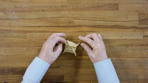 Vista dall'alto su mani maschili che fanno gnocchi, L'uomo fa la pasta e la carne di gnocchi. Cucinando a casa, le mani fanno gnocchi di carne su un tavolo di legno. Gnocchi, farina, porri, mattarello, su tavola di legno . — Foto Stock