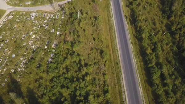 Latające nad pięknym lesie drzew i drogi. Strzał. Widok z lotu ptaka. Samochód na kręte drogi w górach. Anteny kamery strzelać. Panorama pejzaż. Widok z lotu ptaka lotu nad Starym połatany dwie drogi leśne lane — Zdjęcie stockowe