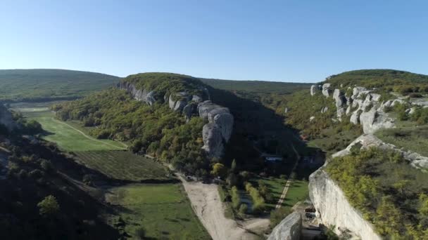 Luchtfoto op het prachtige landschap met bergen, bomen en veld achtergrond. Schot. Bergen met landerijen, dorp, velden met gewassen, bomen. Luchtfoto berglandschap hellingen bergen — Stockvideo