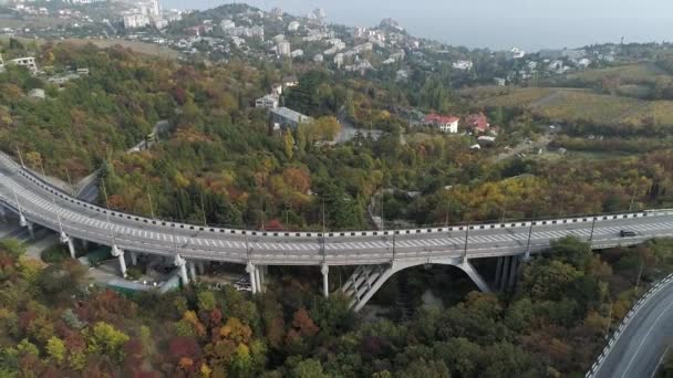 Vue de dessus sur le passage supérieur avec des voitures de conduite, la mer et un beau fond de paysage. Vue aérienne de l'autoroute et du passage supérieur en ville. Jonctions routières — Video