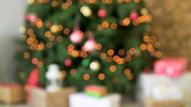 Vista borrosa del árbol de Navidad con luces de hadas. Fondo de Navidad con luces brillantes — Vídeos de Stock