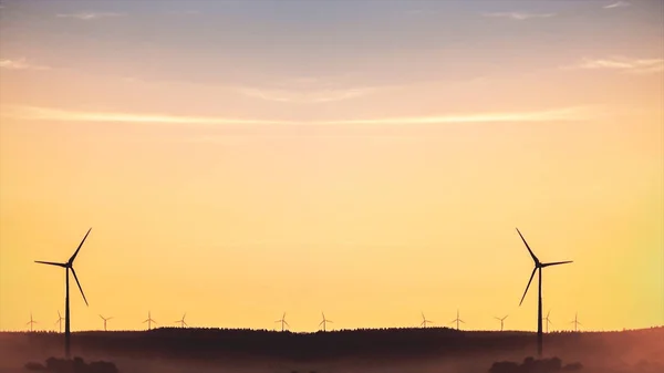 Abstract power windmills on the horizon and a beautiful, golden sunset landscape. Clean and ecological energy generated with the wind of nature through silhouettes of wind turbines, ecology concept.