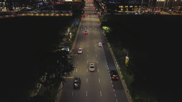 Nacht verkeer verkeer in het midden van de grote stad, stedelijke luchtfoto. Schot. Luchtfoto van de nacht weg met bewegende auto's en prachtige gebouwen. — Stockfoto