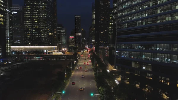 Вид зверху вулиці з автомобілів і сучасних будівель у великий китайський місто вночі. Постріл. Ніч пташиного польоту центр міста з його дороги, переміщення автомобілів, вогні хмарочосів, нічного життя концепція. — стокове фото