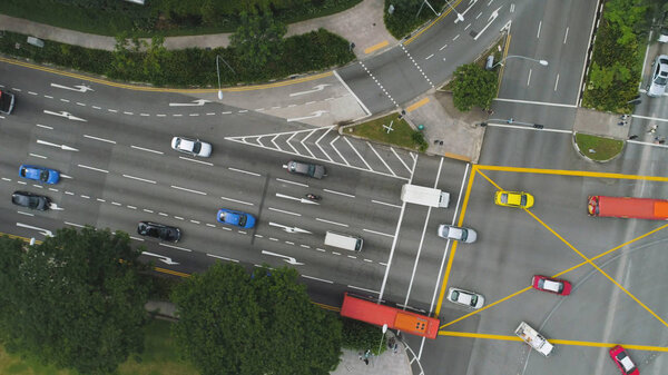 Top view of a city intersection with a bus, cars and people crossing the street. Shot. Traffic at daytime, rossroad in the center of big city, aerial top view.