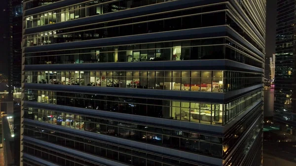 Singapura - 25 de setembro de 2018: reflexo de luzes brilhantes e bonitas nas janelas noturnas do prédio de negócios com fachada de vidro. Atingido. Reflexão luzes bonitas à noite, janelas edifício de escritórios — Fotografia de Stock
