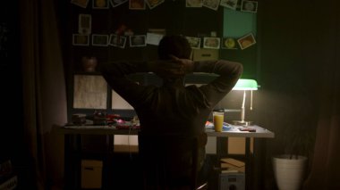 Arka görünümü ile project notları loş ışıklı odasında bir karatahta önünde bir masada oturan bir adam. Hisse senedi. Geriye doğru karanlık odada onun sandalyede oturan adam sanıyor.