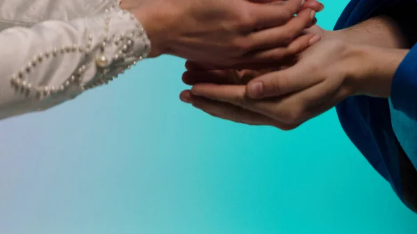 Close up for eastern young woman hands giving many small seashells to man hands, barter concept. Stock. Eastern woman in white dress holding and passing many small seashels to a man. — Stock Photo, Image