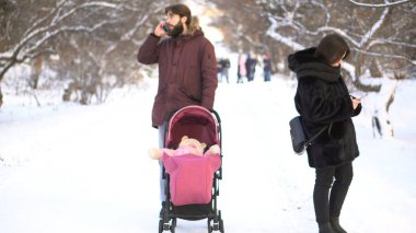 Annem ve babam cep telefonları Bebek arabasındaki bebek ve kış parkta yürürken ihmal bağımlısı. Anne Bebek arabası, bağımlılık, değerler kavramı küçük çocuk görmezden akıllı telefonlar ile meşgul.
