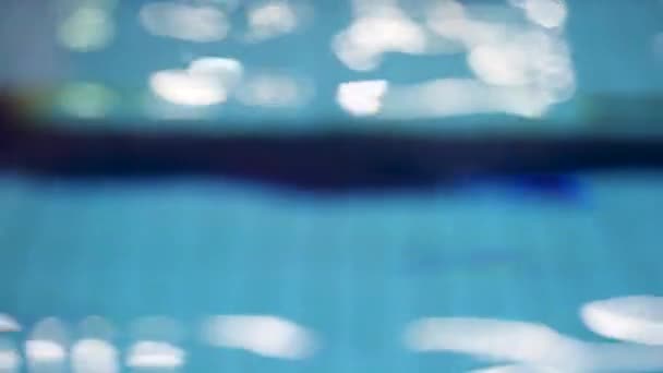 Sfocatura di luce che si riflette nell'acqua blu della piscina. Ondeggiante acqua chiara, struttura dell'acqua della piscina . — Video Stock