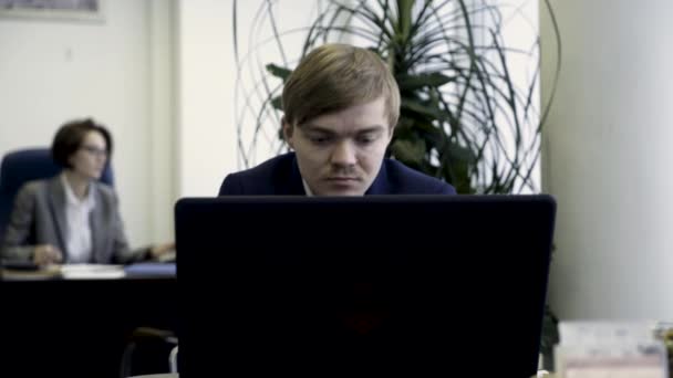 Des hommes d'affaires intelligents tapant sur l'ordinateur sur les lieux de travail dans le bureau moderne. Jeunes collègues de bureau sérieux au travail devant des ordinateurs et des ordinateurs portables . — Video
