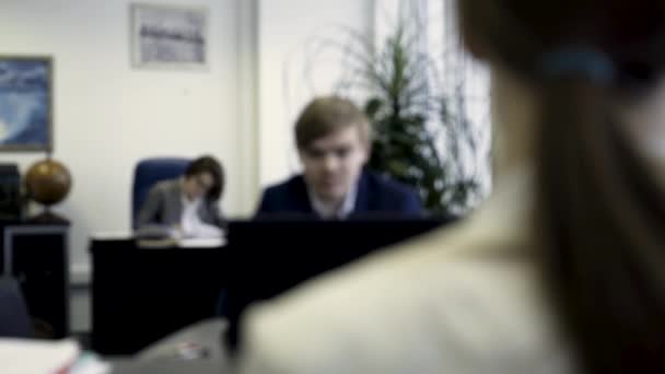 Empresarios inteligentes escribiendo en la computadora en los lugares de trabajo en la oficina moderna. Colegas de oficina jóvenes y serios en el trabajo frente a computadoras y computadoras portátiles . — Vídeo de stock