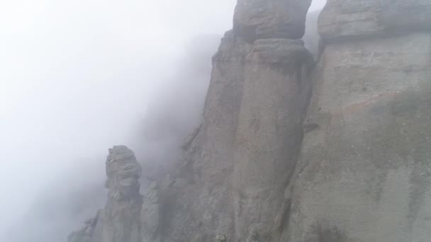 Majestical góry w chmury z żółtym, jesienne drzewa. Strzał. Krajobraz z piękne wysokie skały i dramatyczne mgłę z żółty drzewa, charakter tła. — Wideo stockowe