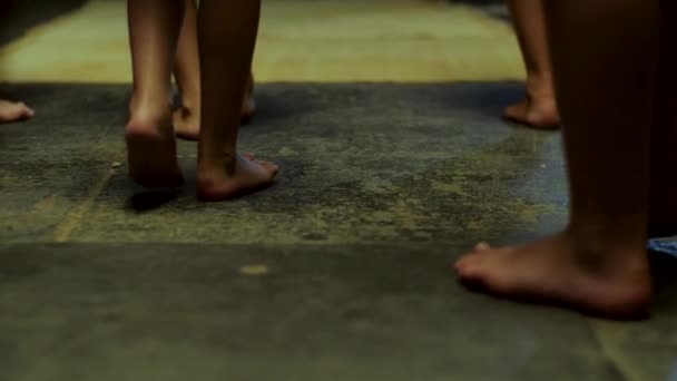 Primer plano para las piernas de los niños corriendo descalzo en la estera amarilla, vista trasera. Escena. Niños piernas corriendo en interiores sin zapatos en el suelo y alfombra amarilla . — Vídeos de Stock