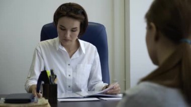 İki iş kadınları ofiste birlikte bir rapor okuma. Kadın patron kadın işçiye raporu denetler