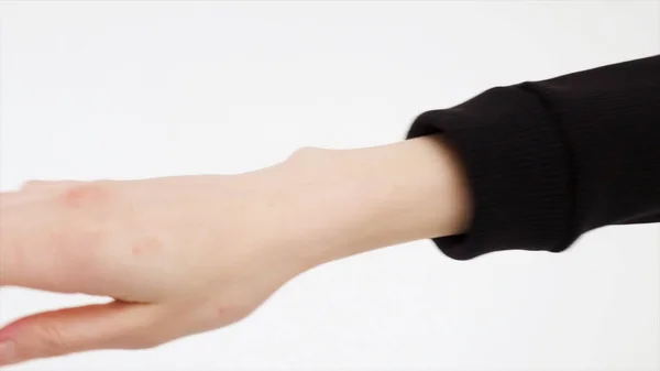 黒いパーカー、白い背景で隔離の置く女性手のクローズ アップ。袖に女性の手をストレッチ黒のタートルネックに置くことのプロセスを閉じる. — ストック写真