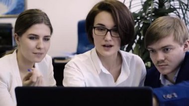 Takım çalışanların bilgisayar başında birlikte çalışır. Yaratıcı ve neşeli çalışanları birlikte bir bilgisayarda Office proje üzerinde çalışır.