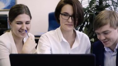 Takım çalışanların bilgisayar başında birlikte çalışır. Yaratıcı ve neşeli çalışanları birlikte bir bilgisayarda Office proje üzerinde çalışır.