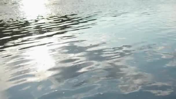 Zblízka vlnky na hladině řeky s mraky odraz ve vodě. V UK. Temné vody v klidné řeky se odráží nebe a slunce. — Stock video