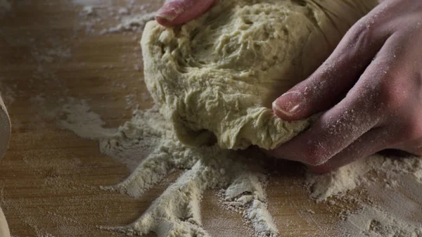 Närbild degen knådas för hand. Scen. Cook knådar degen på tabell beströs med mjöl. Begreppet husmanskost — Stockfoto