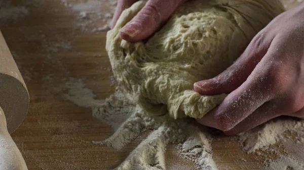 Närbild degen knådas för hand. Scen. Cook knådar degen på tabell beströs med mjöl. Begreppet husmanskost — Stockfoto