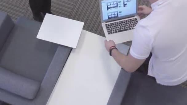 Top view of two young workers with laptops. Stock. Two creative workers sat in chairs where there is Wi - Fi and help each other with work on laptops — Stock Video