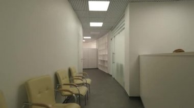 Uzun, arcuate office koridor ve resepsiyon. Koridor duvarları ve birçok kapı sandalye ile bir kamu binası.