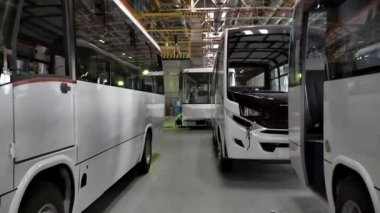 Otobüs üretim satırının bir fabrikada kapatın. Sahne. Kapalı duran otobüs konveyör yeni, modern, beyaz otobüs.