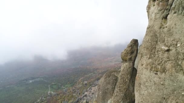 Natur landskap, utsikt från toppen av kullen på gula och gröna dalen i tjock dimma. Skott. Antenn för branta sluttningen av ett berg, gröna och torra fälten i dimmigt moln. — Stockvideo