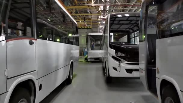 Fechar para linha de produção de ônibus em uma fábrica. Cena. Ônibus novos, modernos e brancos em pé dentro do transportador de ônibus . — Vídeo de Stock