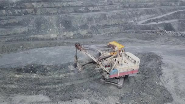 露天矿坑挖掘机的顶视图。在户外采石场开采矿物时, 挖掘机在垃圾桶里睡着了瓦砾。矿物开采的概念 — 图库视频影像
