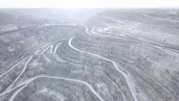 Вид карьеров сверху. Панорамный вид стоящей серой пыли над открытыми ямами с рабочими грузовиками. Концепция горнодобывающей промышленности — стоковое видео