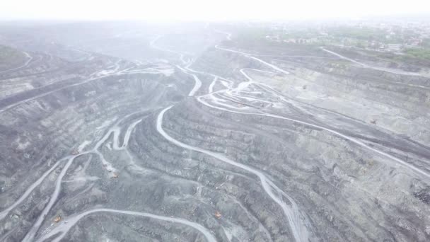 Pohled shora otevřené lomy. Panoramatický pohled stál šedý prach nad otevřené jámy s pracovní vozy. Těžební průmysl početí — Stock video