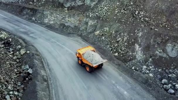 ダンプ トラックは 採石場です 道路露天掘りで瓦礫とオレンジ色のダンプ トラックを運転の平面図です 採鉱産業の重い輸送 — ストック動画