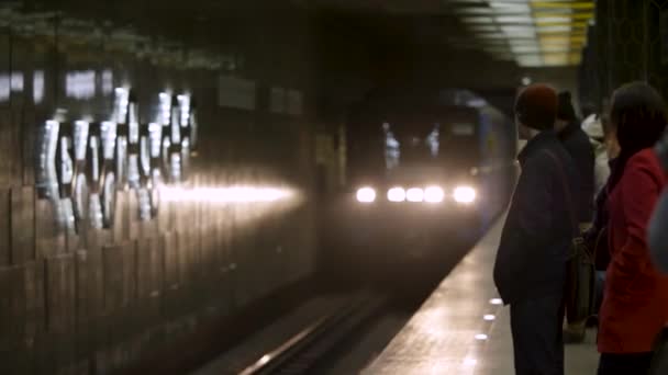 Vindo trem e as pessoas esperando por ele na estação de metro. Carruagem de metrô chegando à estação de metrô com muitos passageiros esperando por ele . — Vídeo de Stock