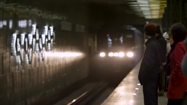 Le train arrive et les gens l'attendent à la station de métro. Transport en métro arrivant à la station de métro avec de nombreux passagers qui l'attendent . — Video