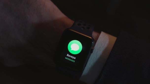 Zbliżenie na czarny zegarek na nadgarstku biznesmena w garnitur z dostarczoną wiadomość i tekst na ekranie na czarnym tle. SMS, dostarczane na placu smartwatch, koncepcja nowoczesnych technologii. — Wideo stockowe