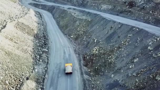 O camião está na pedreira. Vista superior da condução caminhão basculante laranja com entulho na estrada poço aberto. Transportes pesados na indústria mineira — Vídeo de Stock