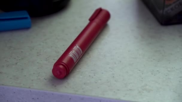 Close-up voor rode marker liggen op de tabel en de hand te nemen. Hand van de blanke man met een ring op een vinger nemen rode voelde pen. — Stockvideo