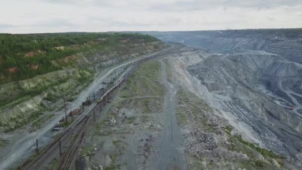 Açık Ocak maden, ön planda, kazılmış malzeme taşıyan incelemesi treni yukarıdan görüntüleyin. Taş ocağındaki tren otomobillerin üstten görünüm — Stok video