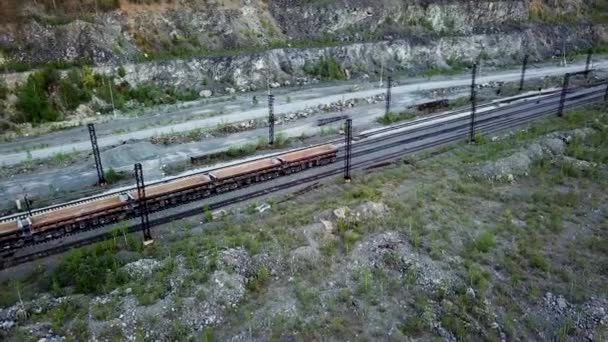 ディーゼル機関車は石灰岩採掘のため採石場の背景に割栗石でいっぱい貨車を推進しています。 — ストック動画