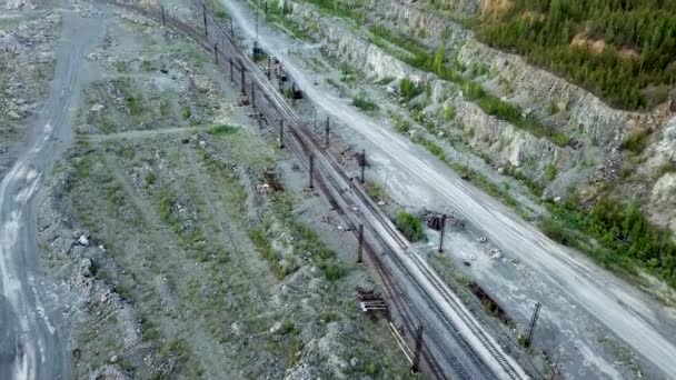Open-pit mine, mijnbouw trein met uitgegraven materialen op het voorplan, bekijken van bovenaf. Bovenaanzicht van de trein auto's bij de steengroeve — Stockvideo