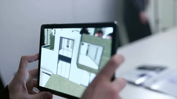 Desenho virtual de casa em pastilha. Estoque. Empresário segurando tablet com projeto de realidade virtual em casa na sala de reuniões. O modelo 3D digital do projeto imobiliário é mostrado no gadget — Fotografia de Stock