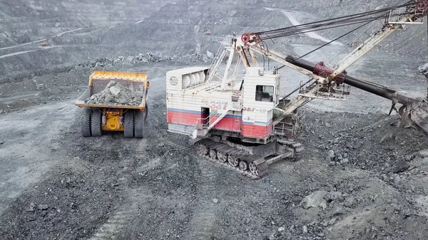 露天矿坑挖掘机的顶视图。在户外采石场开采矿物时, 挖掘机在垃圾桶里睡着了瓦砾。矿物开采的概念 — 图库照片