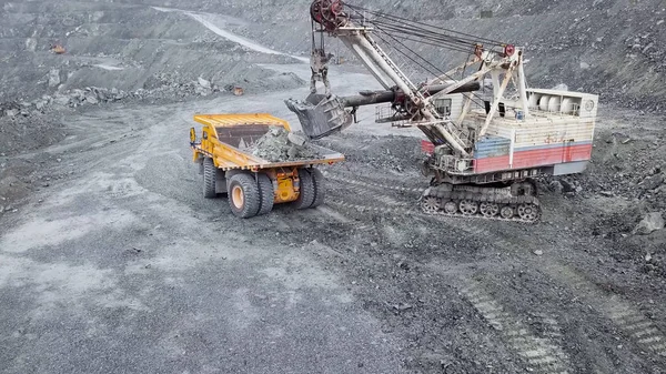 Vista superior de la excavadora en foso abierto. Excavadora cae escombros dormidos en vertedero en cantera al aire libre en la extracción de minerales. Concepto de extracción de minerales — Foto de Stock