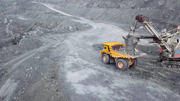 Vista superior de la excavadora en foso abierto. Excavadora cae escombros dormidos en vertedero en cantera al aire libre en la extracción de minerales. Concepto de extracción de minerales — Foto de Stock